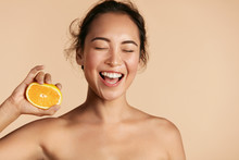 Beauty. Smiling Woman With Radiant Face Skin And Orange Portrait. Beautiful Smiling Asian Girl Model With Natural Makeup, Healthy Smile And Glowing Hydrated Facial Skin. Vitamin C Cosmetics Concept