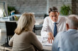 © Drazen - Insurance agent consulting senior couple about their retirement plans in the office.