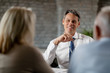 © Drazen - Happy real estate agent having a meeting with senior clients in the office.