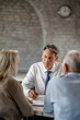 © Drazen - Bank manager and senior couple going through financial reports during a meeting.