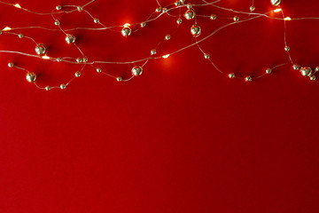 Christmas background. Beads and garland on a red background