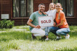 © Yakobchuk Olena - Happy family holding sold card and smiling