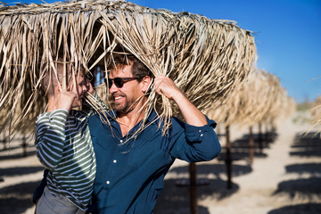 Wall Mural - Father with small son on a walk outdoors on beach, having fun.