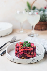 Wall Mural - Russian beetroot salad vinaigrette in a white plate over light background