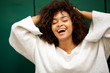 © mimagephotos - Close up laughing young african american with hands in hair