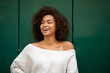 © mimagephotos - laughing young african american woman against green background