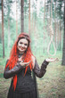 Beautiful smiling woman witch with hangman loop in the forest