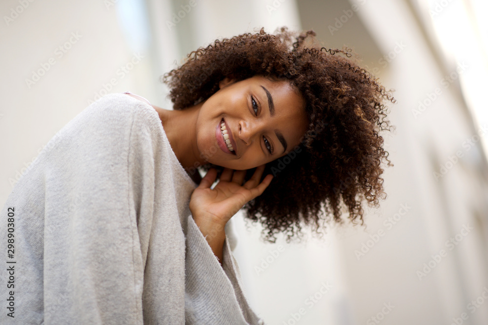 Close up happy young african american woman with curly hair smiling ...