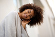 © mimagephotos - Close up happy young african american woman with curly hair smiling outside