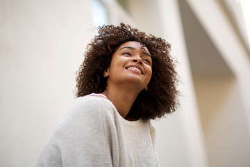 Wall Mural - close up happy african american woman with curly hair smiling outside