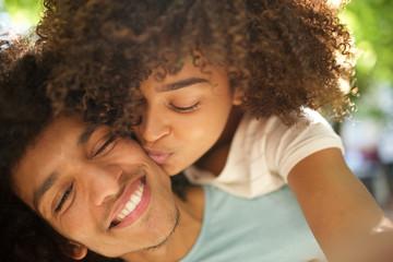 Wall Mural - happy young african american couple kissing while young woman is piggyback