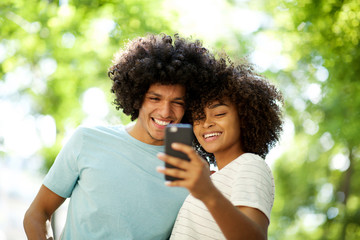 Wall Mural - happy afro guy taking selfie with smiling young african american woman