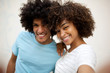 © mimagephotos - Close up happy african american couple taking selfie by white background