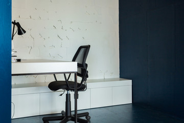 Wall Mural - Loft style office with white brick walls and concrete columns. There is a meeting area with a large white table with black chairs