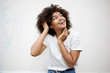 © mimagephotos - cheerful young african american woman laughing and looking up by white background