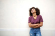© mimagephotos - cool african american girl laughing with arms crossed by white wall