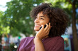 © mimagephotos - smiling young african american woman talking with cellphone outdoors