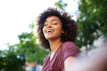 Wall Mural - happy african american woman taking selfie outside