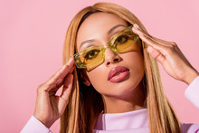 Portrait Of Stylish, Blonde African American Woman Touching Glasses Isolated On Pink, Fashion Doll Concept