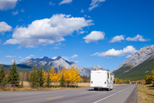 An RV Aon The Highway Through The Canadian Rocky Mountains In Kananaskis, Alberta, Canada During The Peak Of Autumn Colors