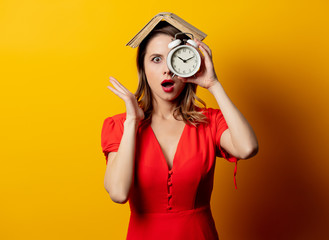 Wall Mural - Beautiful woman in red dress with alarm clock