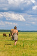 © shymar27 - A girl on a field among horses, against a background of sky and clouds.