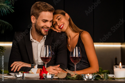 Fotomural Excited loving couple celebrating special event with wine and candles , having d