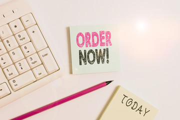 Text sign showing Order Now. Business photo showcasing confirmed request by one party to another to buy sell White pc keyboard with empty note paper and pencil above white background