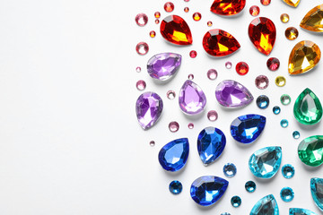 Different beautiful gemstones on white background, top view