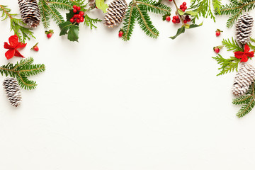 Wall Mural - christmas background with pine cones, branches of holly with red berries and fir tree on white. wint