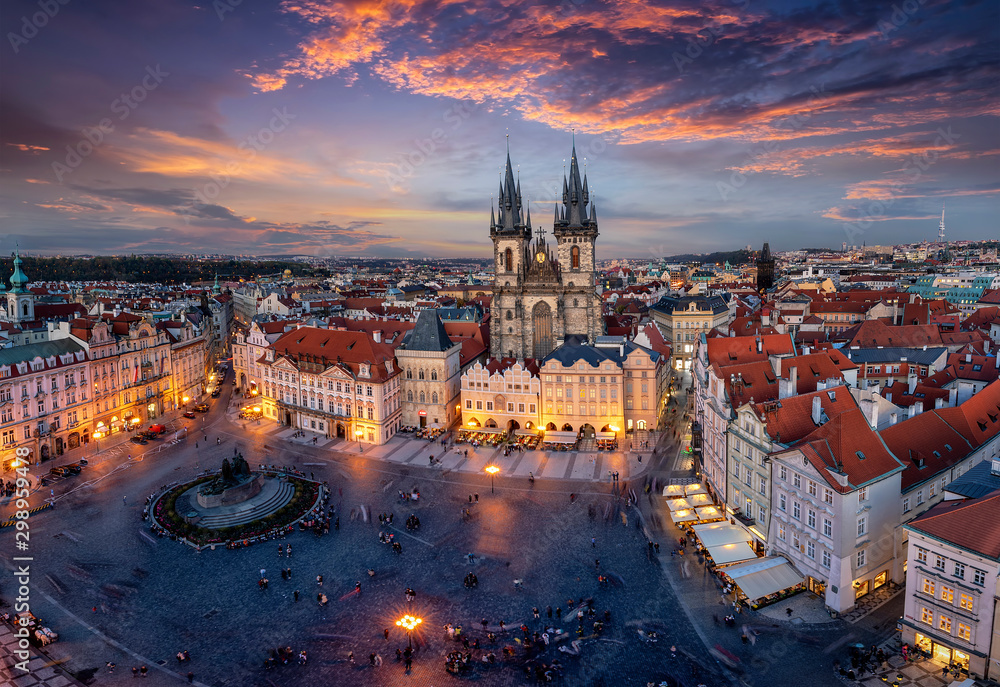 Blick über die Dächer der Altstadt und den zentralen Platz von Prag zur beleuchteten Teynkirche am Abend nach Sonnenuntergang, Tschechien - obrazy, fototapety, plakaty 