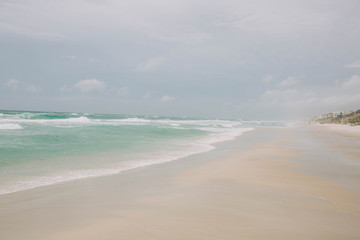 Beach with light blue water and white sand