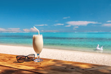 Coconut Shake Pina Colada Drink Cocktail Milkshake At Beach Bar In Bora Bora Island, Tahiti, French Polynesia. Ocean View With Tall Milk Drinking Glass On Table.