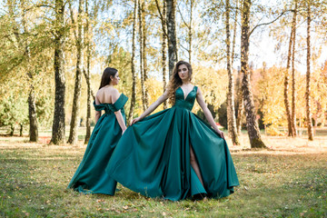  Ladies in elegant green dresses walking in autumn park. Brunette girl Dreamy young girls laughing on the outdoors
