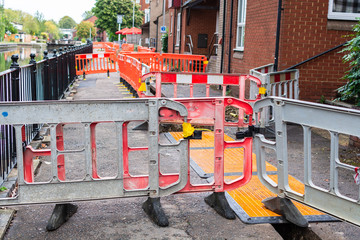 Pathway closed for work with orange and red stoppers, in urban setting