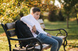© Aleksandr - Young boy take out of his pocket smartphone. Teenage boy sitting on the bench in the park