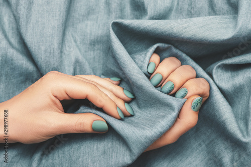 Εκτύπωση καμβά Close up view of woman hands with trendy manicure on jeans cloth background