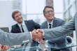 © ASDF - handshake of business people on a blurred office background.