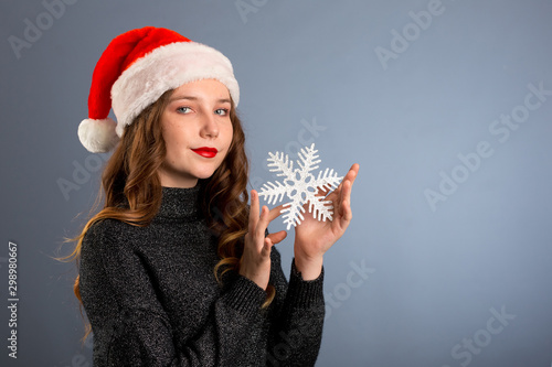 Girl In Santa Hat Portrait With Big Silver Snowflake Toy Posing On Gray Color Background Christmas Holiday Concept Happy And Emotions On Isolated Gray Background Buy This Stock Photo And Explore