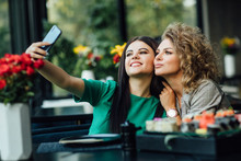 Pretty Girls, Partners Taking A Picture By The Cell Phone With Sushi Plate On Table. Selfie Time.
