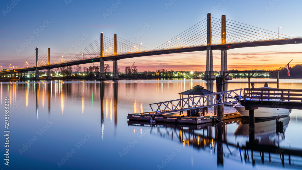 Vancouver, British Columbia - Canada. The Golden Ears Bridge, connecting Maple Ridge to Langley. Long exposure at night, Sky and bridge reflecting into Fraser River.