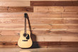 © Pixel-Shot - Modern acoustic guitar near wooden wall
