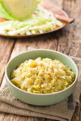 Wall Mural - Fresh homemade braised white cabbage in bowl, raw cabbage in the back (Selective Focus, Focus one third into the cabbage)