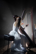 Girl Playing The Harp On Stage