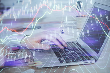 Multi exposure of stock market graph with man working on laptop on background. Concept of financial analysis.