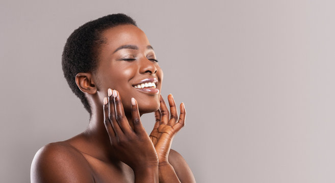 happy afro woman touching soft smooth skin on her face