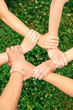 © Viktoriia - Volunteering. Young people volunteers outdoors together holding hands unity top view close-up