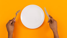Black Female Hands Holding Empty Plate On Orange Background, Top View, Free Space