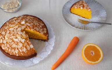 Freshly baked homemade cake of carrots and almonds. One piece ready to eat. Clear background and orange color