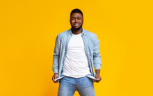 Desperate African American Guy Showing Empty Pockets Over Yellow Background